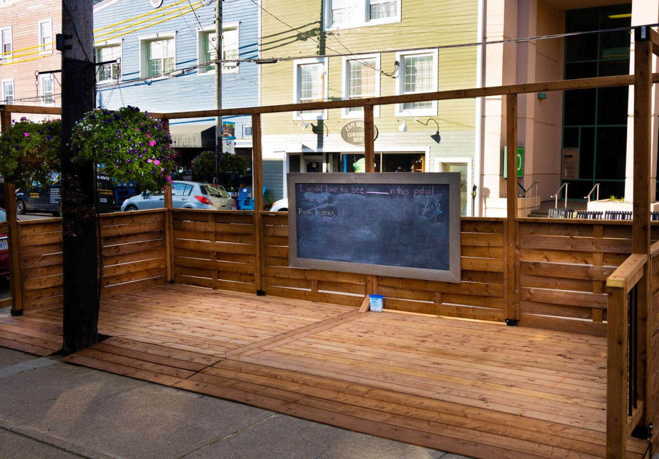 Wooden patio off of sidewalk and into the street in downtown setting